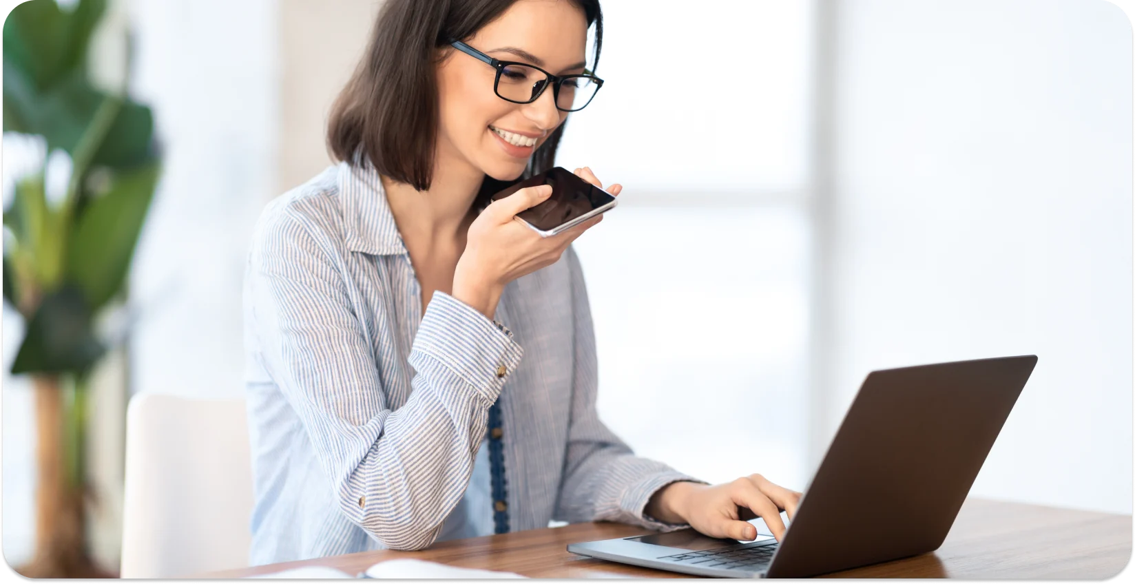 Woman uses audio transcription on her phone to convert speech to text, boosting work efficiency.
