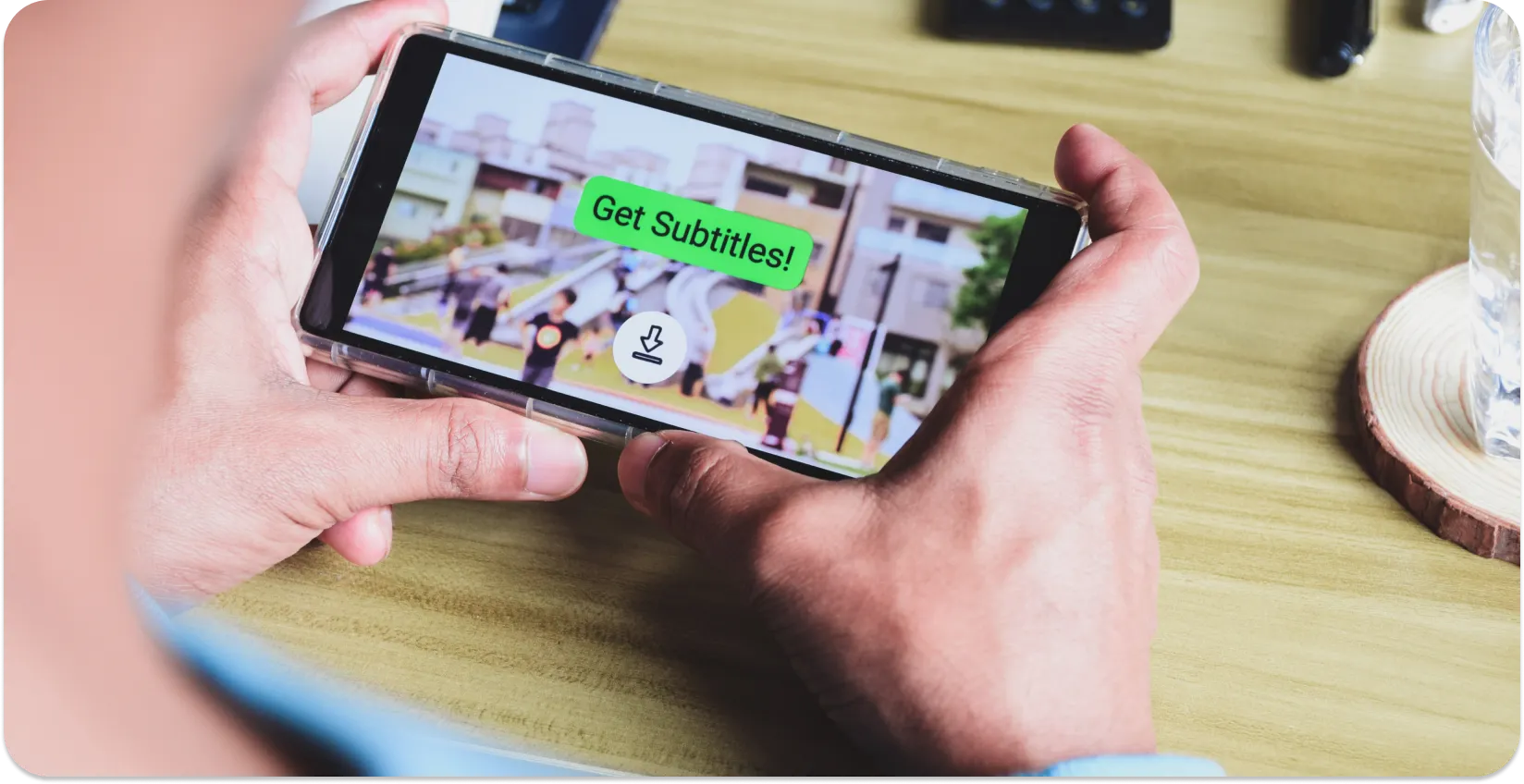 Hands holding a smartphone displaying a 'Get Subtitles!' button, indicative of the ease of adding subtitles.